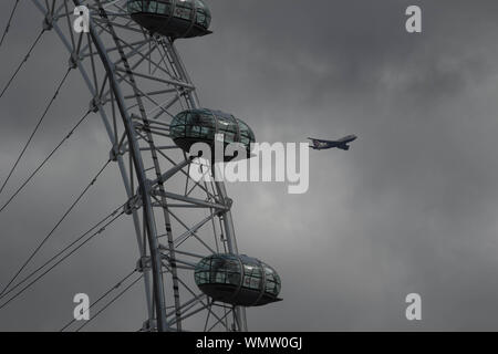 Londres, Royaume-Uni. 12Th Mar, 2019. Un avion survole le London Eye en ciel nuageux avec un mélange de l'automne météo à Londres. Credit : Amer Ghazzal SOPA/Images/ZUMA/Alamy Fil Live News Banque D'Images