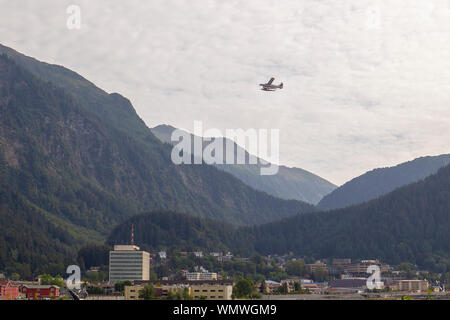 Le centre-ville de Juneau en Alaska à partir de l'île Douglas avec un hydravion décollant de la Canal Gastineau. Banque D'Images