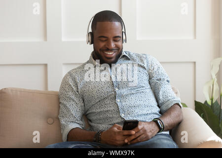 Handsome young african american guy portant un casque Bluetooth sans fil. Banque D'Images
