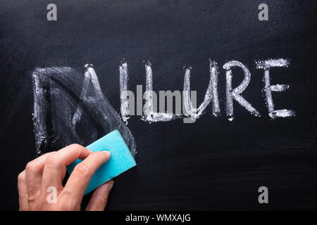 Close-up of Hand dépose Mot Échec Written on Chalkboard Banque D'Images