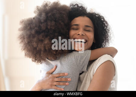 Heureux heureux seul african american mother cuddling petite fille d'âge préscolaire. Banque D'Images