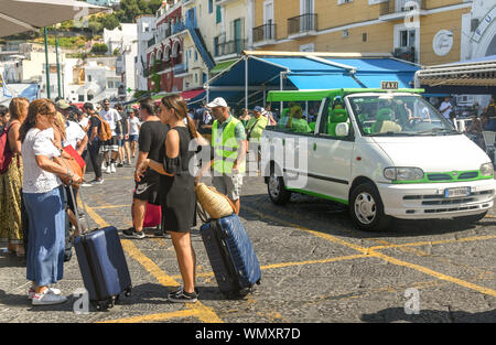 Île de Capri, ITALIE - AOÛT 2019 : les personnes avec bagages à la station de taxis dans le port sur l'île de Capri après son arrivée sur un ferry. Banque D'Images