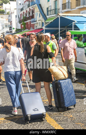 Île de Capri, ITALIE - AOÛT 2019 : les personnes avec bagages à la station de taxis dans le port sur l'île de Capri après son arrivée sur un ferry. Banque D'Images