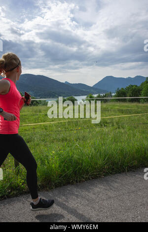 Fit woman court le long chemin de terre en guêtres noires et rose top Banque D'Images