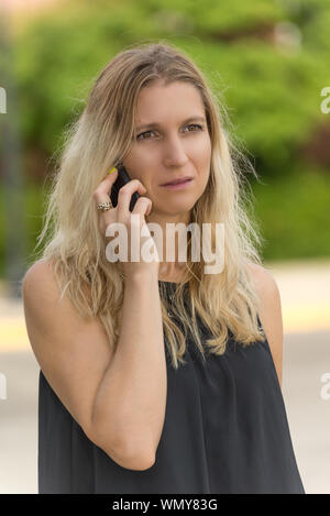 Worried woman recevoir de mauvaises nouvelles au téléphone Banque D'Images