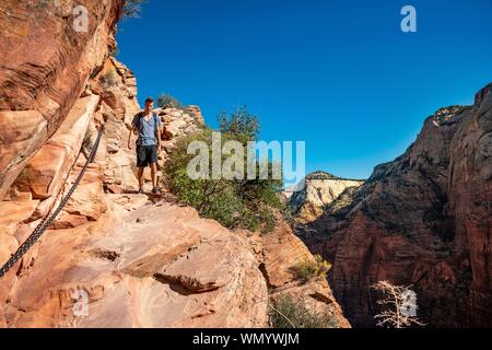 Jeune homme randonnée sur Angels Landing Trail, Zion National Park, Utah, USA Banque D'Images