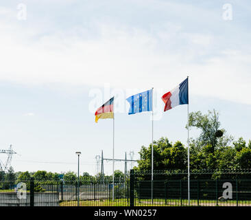 Nationale française et allemande de l'Union européenne avec les drapeaux nationaux au milieu de brandir le drapeau bleu à la frontière entre les deux pays Banque D'Images