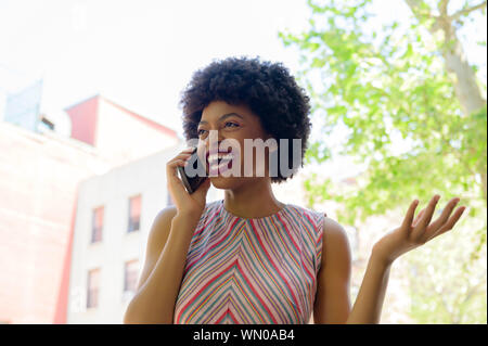 Smiling young woman on phone call Banque D'Images