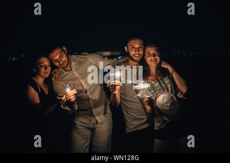 Les jeunes jouant avec cierges dans la nuit. Best Friends hanging out at night sur la falaise de montagne Banque D'Images