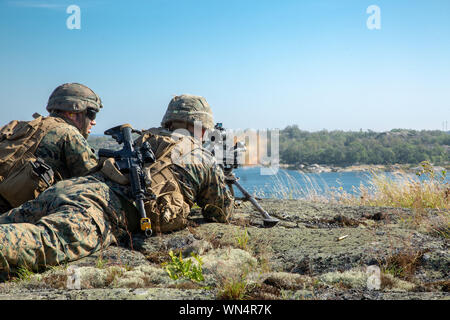 Les Marines américains avec 1er Bataillon, 8ème Marines, Force de rotation maritime-Europe 19.2, Forces maritimes de l'Europe et l'Afrique, fournir un tir de suppression pendant un raid de l'archipel dans le cadre de l'exercice s'efforcer Archipel 19 îles dans l'archipel, la Suède, le 28 août 2019. 19 est une entreprise de l'archipel, intégré sur le terrain bilatéral annuel-entraînement, menée pour promouvoir l'interopérabilité, à renforcer les partenariats et de renforcer la coopération stratégique et tactique entre les États-Unis et l'Agence suédoise des Marines. (U.S. Marine Corps photo par Lance Cpl. Joseph Atiyeh) Banque D'Images