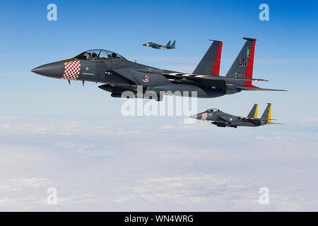 Deux F-15E Strike Eagles et un F-15C Eagle affecté à la 48e Escadre de chasse peint avec leurs couleurs respectives du patrimoine de l'escadron mener des manœuvres aériennes dans le sud de l'Angleterre le 3 septembre 2019. L'aile de la liberté d'entraînement de routine effectue chaque jour pour assurer la 48e Escadre de chasse apporte des capacités de combat de l'air unique à la lutte lorsqu'il est appelé par l'United States Air Forces in Europe-Air Afrique Forces. (U.S. Air Force photo/ Tech. Le Sgt. Matthew Plew) Banque D'Images