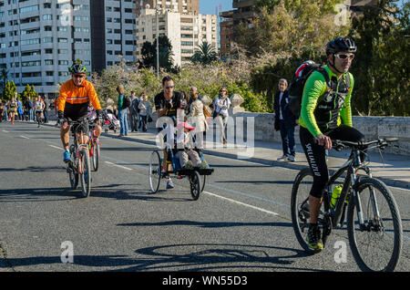 Homme qui va pousser son fils dans la voiture de marathon de Valence en Espagne le 16 novembre 2014 Banque D'Images