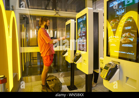 Dubaï, Émirats arabes unis - circa 2019, février : Utiliser des bornes de commande restaurant McDonald à l'Aéroport International de Dubaï. Banque D'Images