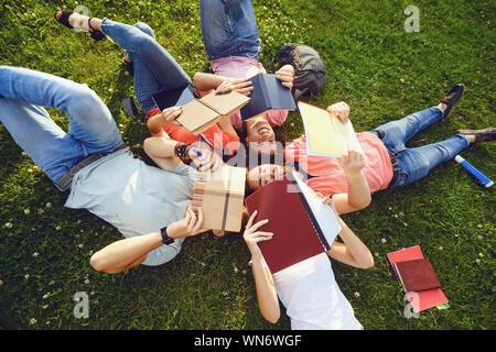 Les jeunes rient en position couchée sur l'herbe Banque D'Images