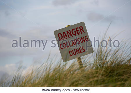 Un panneau met en garde du danger de s'effondrer dans les dunes près de Rosses Point Sligo Banque D'Images