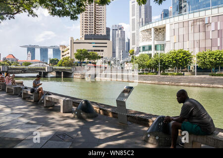 Singapour - 8 juillet 2019 : Les gens de vous détendre au bord de la rivière Singapour. La rivière traverse le centre-ville. Banque D'Images