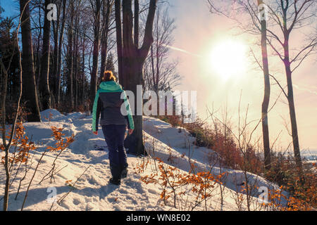 Femme rousse randonnée à travers un paysage hivernal merveilleux dans la forêt près de Zell am Pettenfirst, Autriche Banque D'Images