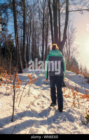 Femme rousse randonnée à travers un paysage hivernal merveilleux dans la forêt près de Zell am Pettenfirst, Autriche Banque D'Images