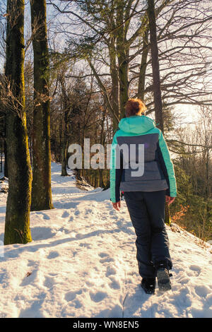 Femme rousse randonnée à travers un paysage hivernal merveilleux dans la forêt près de Zell am Pettenfirst, Autriche Banque D'Images