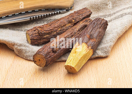 Groupe de réglisse bâton de réglisse racine naturelle (bars). Paloduz ou usine de réglisse (Glycyrrhiza glabra, orozuz). Décortiquées avec rasoir. Sur fond de bois Banque D'Images