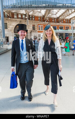 L'Angleterre, Londres, Lambeth, Waterloo hall de gare, l'homme en haut de forme et queue marcher avec femme de former pour les courses d'Ascot Banque D'Images