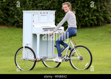 Busker Ilfracombe Chloe Aston représenté sur son vélo piano unique qu'elle utilise pour divertir les foules quand elle effectue Banque D'Images