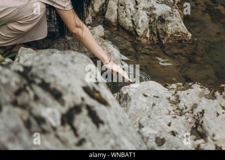 Close-up of a Girl de toucher l'eau dans une rivière ou un étang ou lac. L'unité avec la nature. Banque D'Images