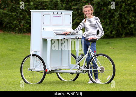 Busker Ilfracombe Chloe Aston représenté sur son vélo piano unique qu'elle utilise pour divertir les foules quand elle effectue Banque D'Images