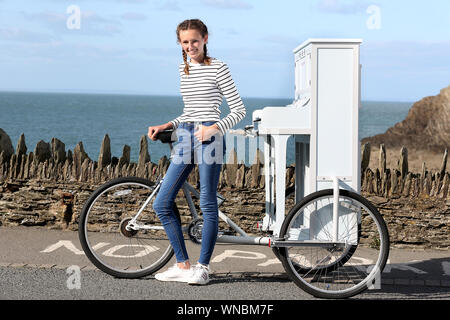 Busker Ilfracombe Chloe Aston représenté sur son vélo piano unique qu'elle utilise pour divertir les foules quand elle effectue Banque D'Images