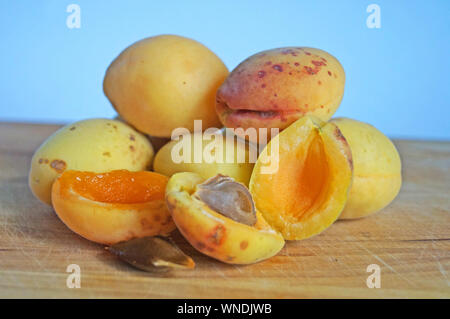 Les abricots mûrs et juteux et de pêches avec des écorces d'orange et jaune se coucher sur une table en bois Banque D'Images