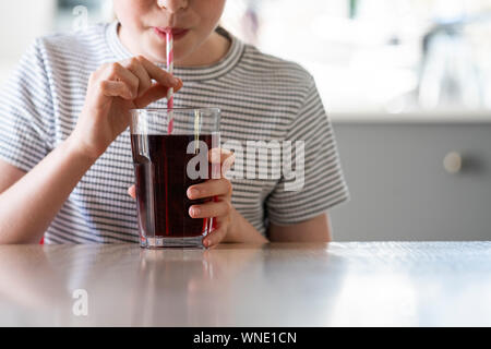 Close Up of Girl Drinking Soda pétillant sucré avec de la paille de verre Banque D'Images