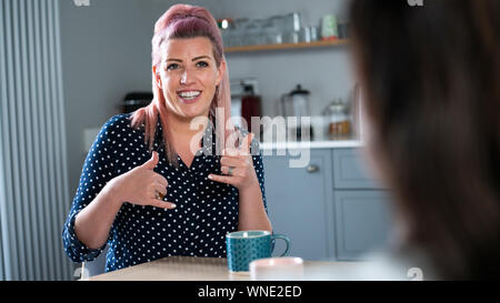 Fermer UpOf Woman Having Conversation à la maison en utilisant la langue des signes Banque D'Images