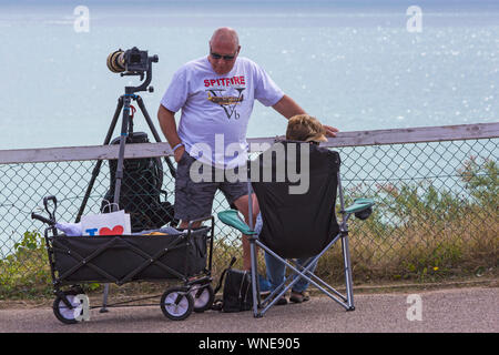 Homme portant un t-shirt Spitfire avec caméra et objectif sur trépied à Bournemouth, Dorset UK Air Festival en août Banque D'Images