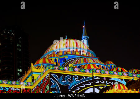 Beaux motifs moyen-orientaux colorés affichés sur une mosquée dans la ville la nuit - Sharjah lights festival Banque D'Images