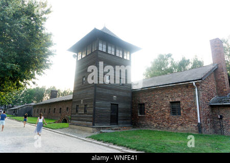 Les visiteurs passent devant une tour de garde au camp de concentration d'Auschwitz et en Pologne, le 29 août 2019. Banque D'Images