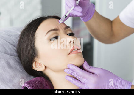 Asian woman receiving injection en imiter ride sur le front . Retrait procédure ride Banque D'Images