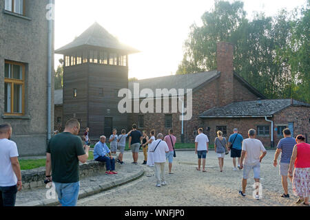 Les touristes passent devant une tour de garde au camp de concentration d'Auschwitz et en Pologne, le 29 août 2019. Banque D'Images