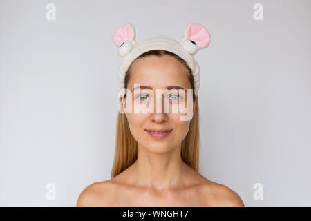 Portrait d'une jeune femme sur fond blanc. Soins de la peau et des soins spa à domicile ou salon de beauté. Concept de cosmétologie Banque D'Images