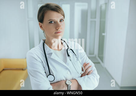Middle aged female doctor standing in hospital corridor with stethoscope Banque D'Images