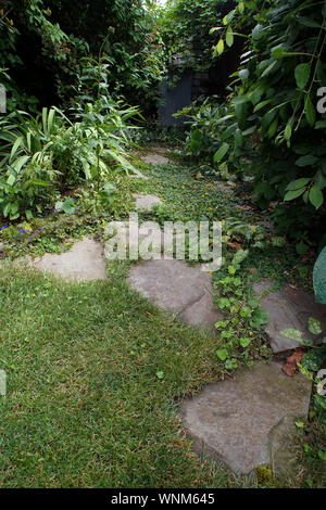 Chemin fait de pierres split mis dans le jardin pelouse Banque D'Images