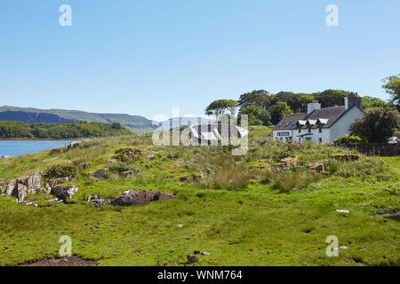 Le Boathouse restaurant de fruits de mer et vieux bateau de pêche sur l'île d'Ulva à la recherche de l'île de Mull, Hébrides intérieures, Ecosse, Royaume-Uni Banque D'Images