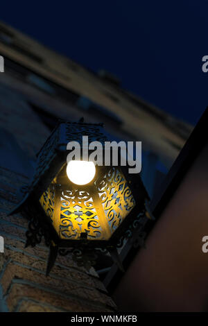 Une seule lampe et ampoule lumineux monté sur la paroi d'un immeuble dans la nuit Banque D'Images