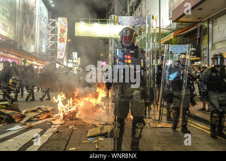 Kowloon, Hong Kong. Sep 6, 2019. Les agents de la police anti-émeute, l'incendie qui a été ordures surround réglé par les manifestants le vendredi 6 septembre, 2019.Dans la ville de Mong Kok, Kowloon Hong Kong.Des milliers de manifestants se sont réunis à l'extérieur du poste de police de Mong Kok et autour de cette zone pour protester contre la violence policière contre les citoyens de Hong Kong.manifestants déplacé Nathan Rd au sud, de détruire les caméras de surveillance, les plaques de rue, des barricades avec des volets en bois et de bancs puis mis le feu comme ils se déplacent sur.9/6/2019.Kowloon, Hong Kong. Credit : ZUMA Press, Inc./Alamy Live News Banque D'Images