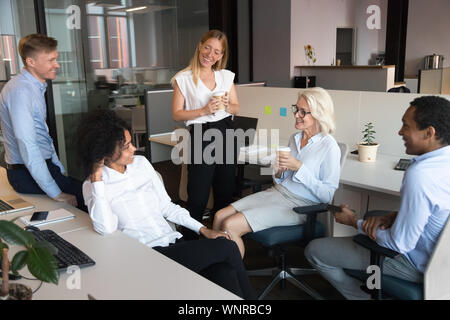 Smiling employés parlent en réunion informelle à espace ouvert Banque D'Images