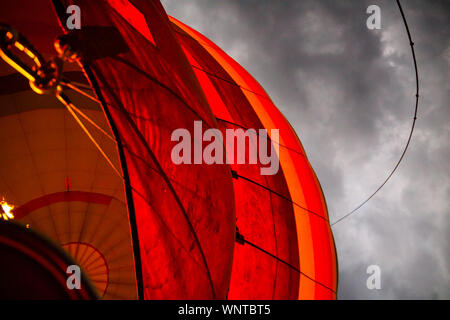 Le soleil se lève sur un jour nuageux, flottant au-dessus des fermes dans le Masai Mara dans un ballon à air chaud. Banque D'Images