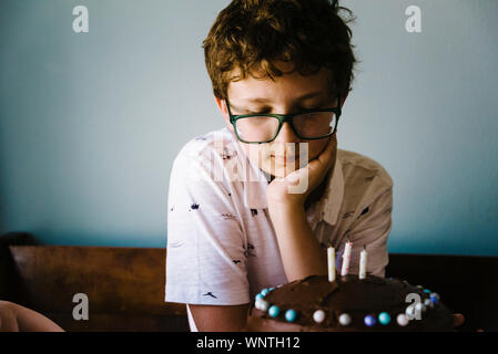 Le Tween garçon admirant son gâteau d'anniversaire après le décorer. Banque D'Images