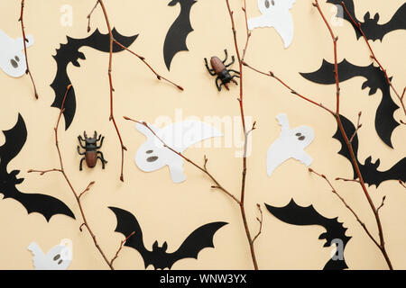 Happy Halloween concept. Décorations d'Halloween, les chauves-souris, fantômes, araignées sur fond beige pastel. Halloween party carte de vœux. Mise à plat, vue du dessus, o Banque D'Images