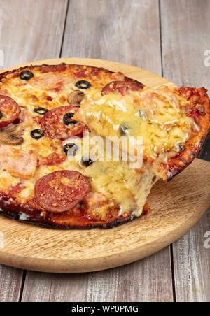 La pizza sur un vieux fond de studio en bois Banque D'Images