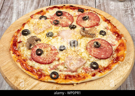 La pizza sur un vieux fond de studio en bois Banque D'Images