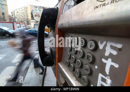 Bucarest, Roumanie - 15 novembre 2018 : Une utilisation de vieux téléphone public avec des boutons dans un état de dégradation avancé est monté sur le mur en bas Banque D'Images